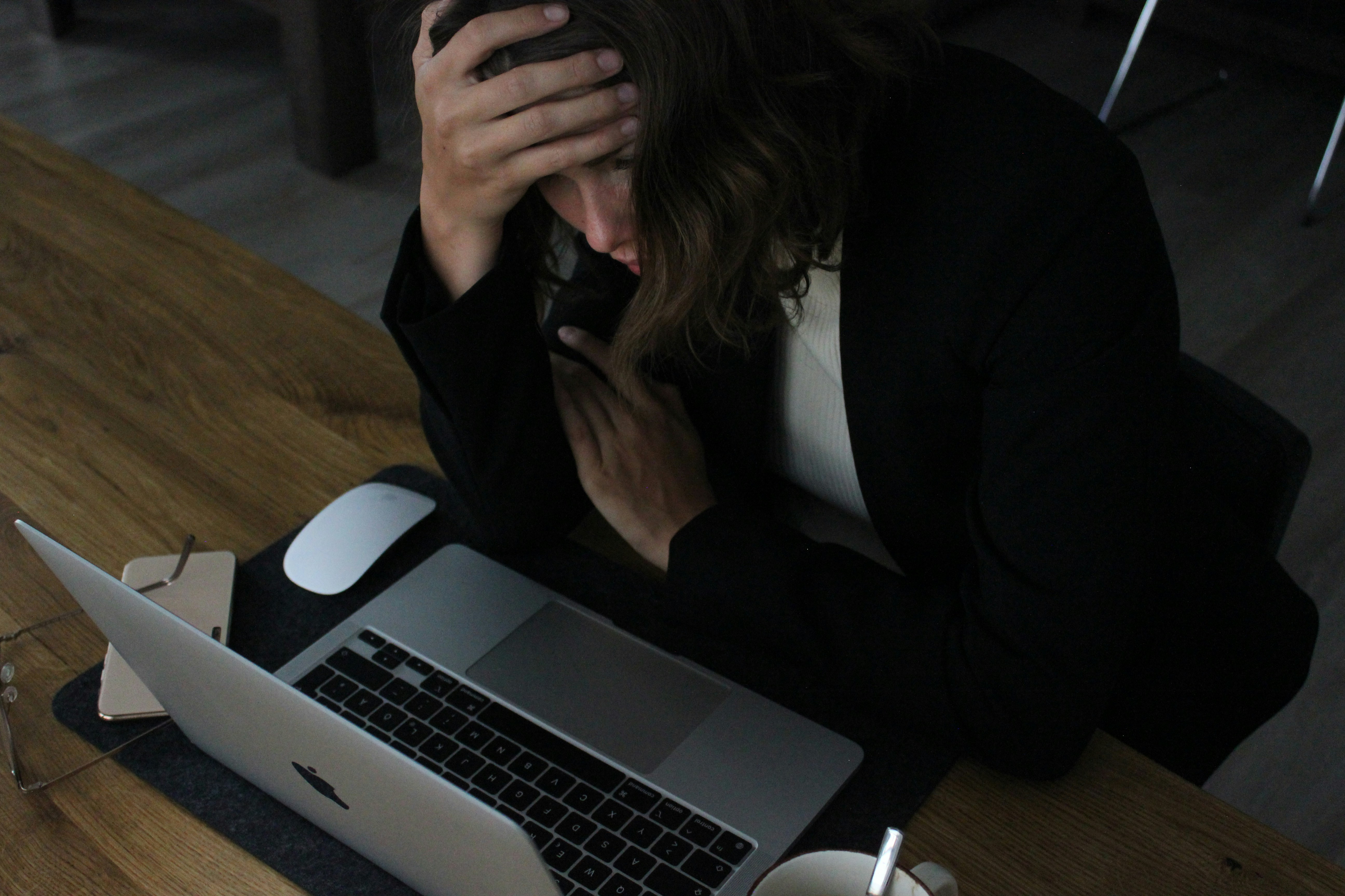 A stressed professional working late on a laptop