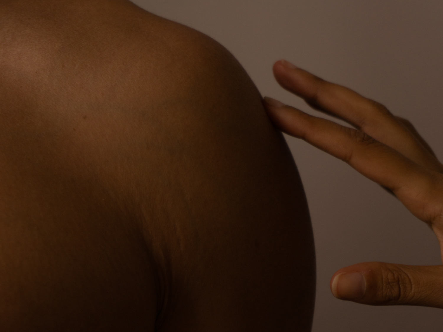 A hand resting gently on a shoulder — the practice of affective touch